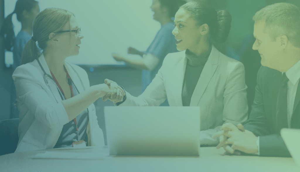 Female doctor shaking hands with a businesswoman in a meeting