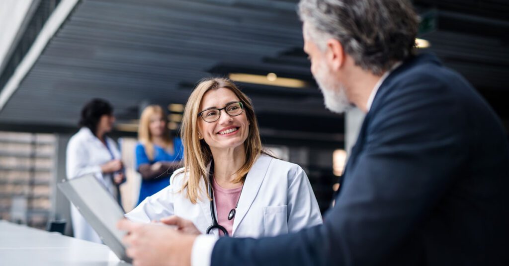 Smiling female doctor in conversation with a man in an office