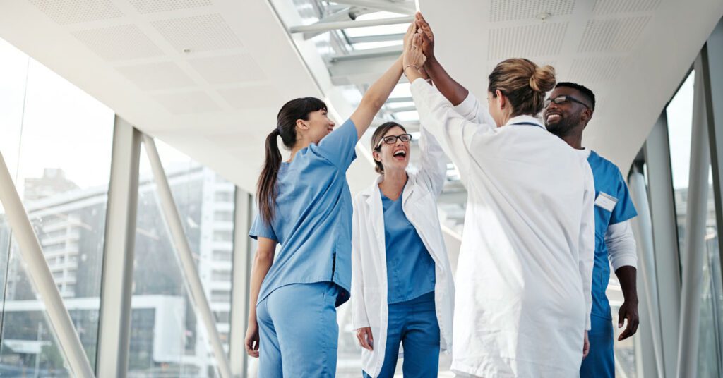 Diverse group of healthcare professionals celebrating with a high-five