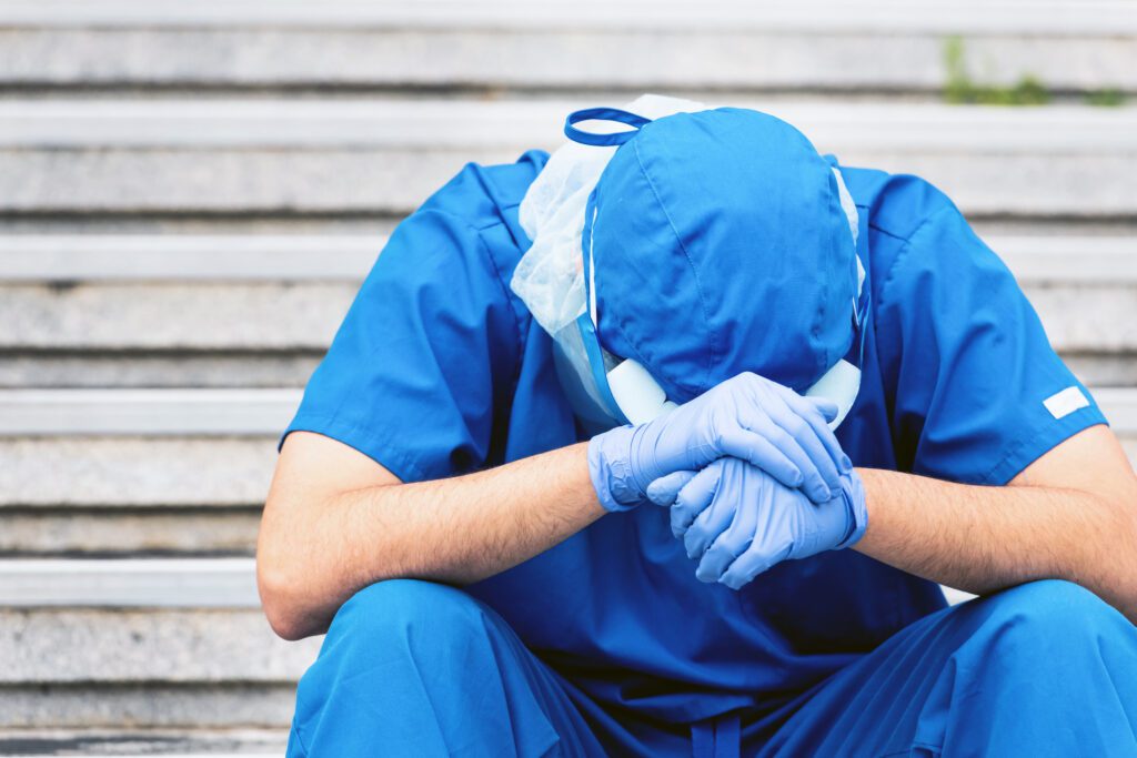 Doctor sitting on a staircase with his head in his hands