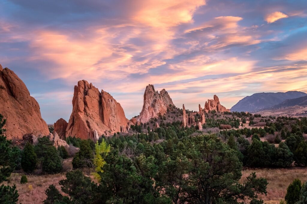 Sunset view of red rock formations surrounded by lush greenery