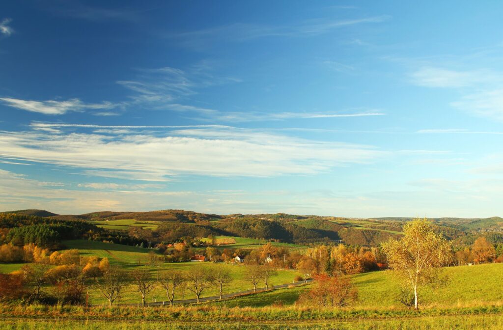 Scenic landscape view of rolling hills, green fields, and scattered trees