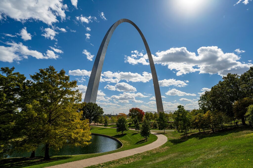 St Louis Gateway Arch towering over lush park on sunny day