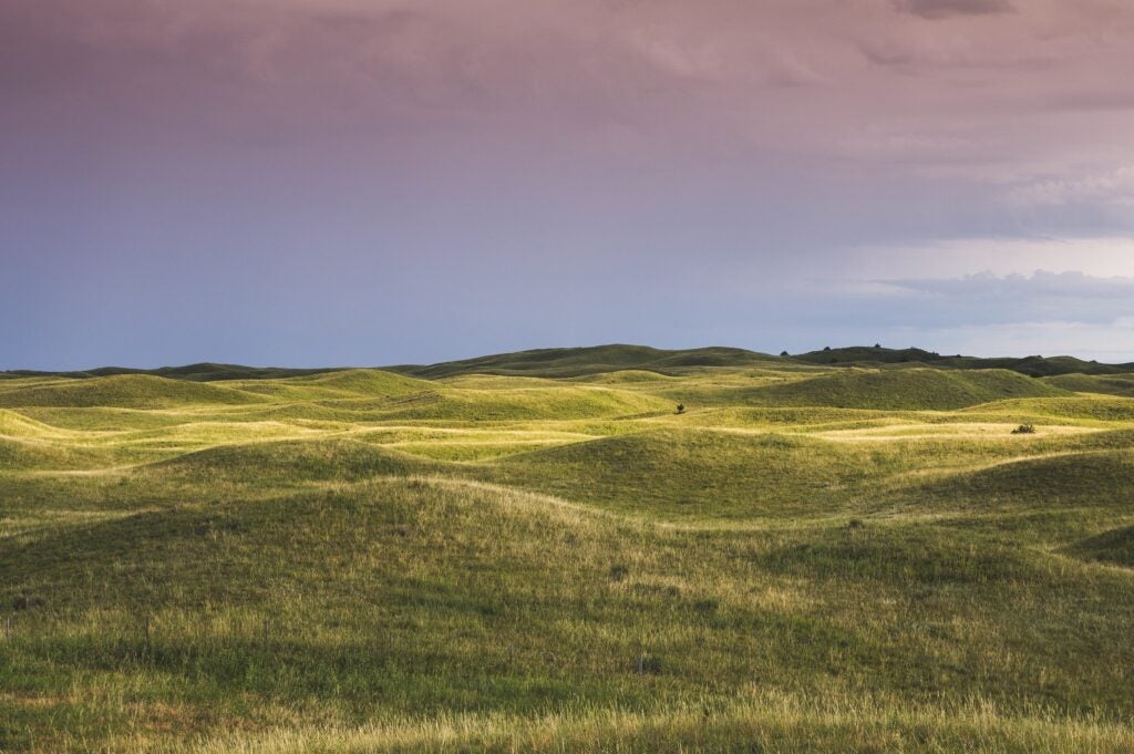 Nebraska's Vast grassy rolling hills under a cloudy sky