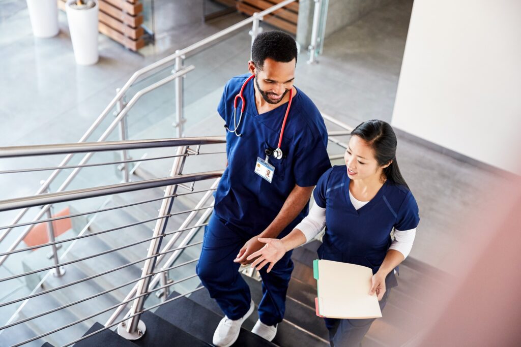 Two healthcare professionals walking up a staircase