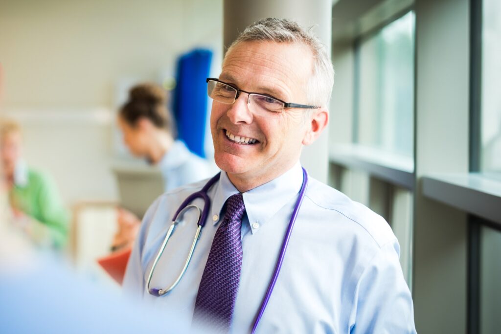 seasoned doctor smiling at work