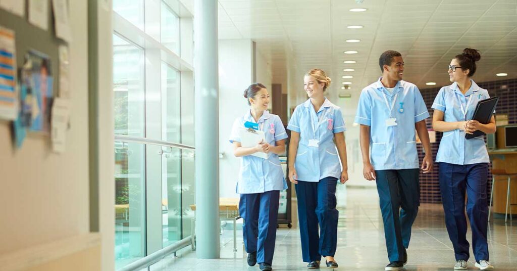 Group of healthcare professional walking and talking in a hospital corridor