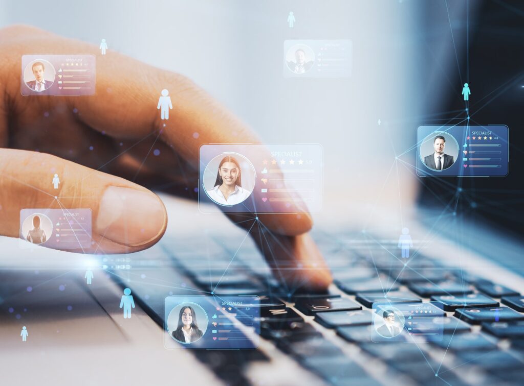 Hand interacting with digital profiles on a laptop's futuristic interface