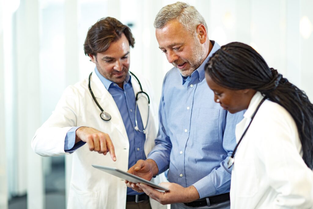 Two doctors showing a tablet to a man