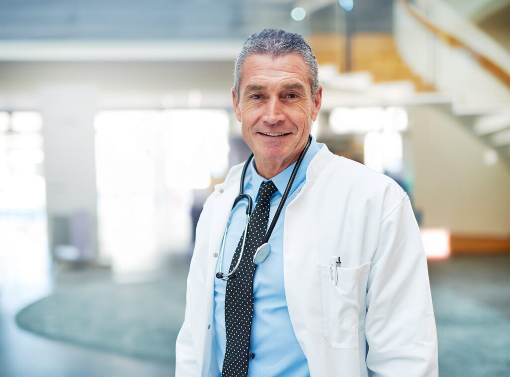 A smiling doctor standing in hospital corridor