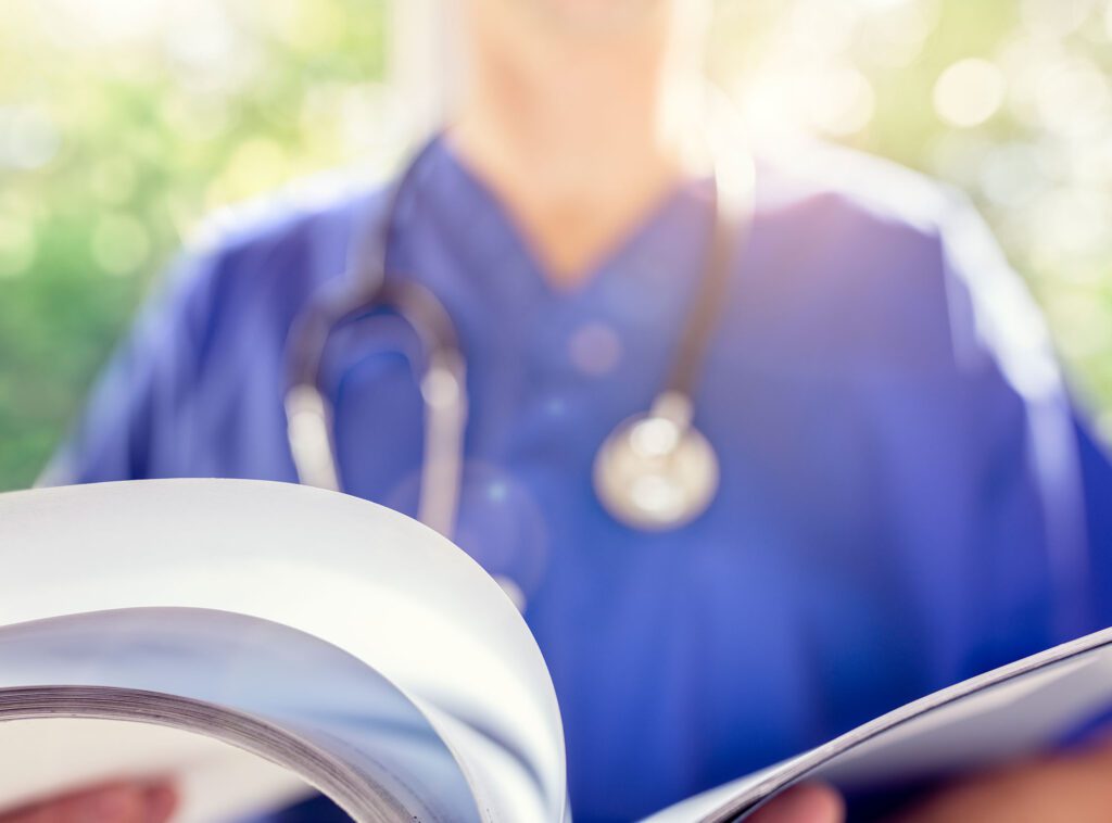 Healthcare professional reading a medical report in a sunny room