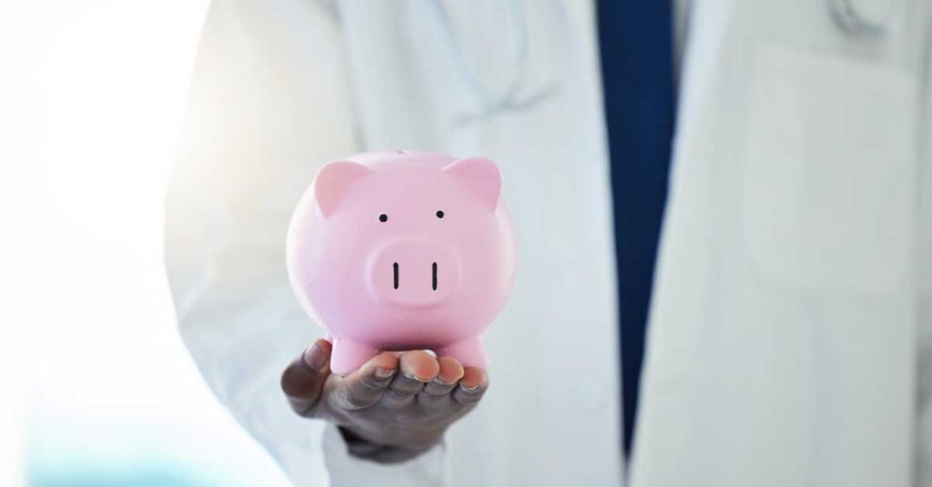 Doctor holding a pink piggy bank