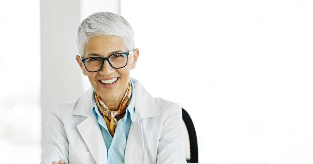 Female doctor smiling while seated on a chair