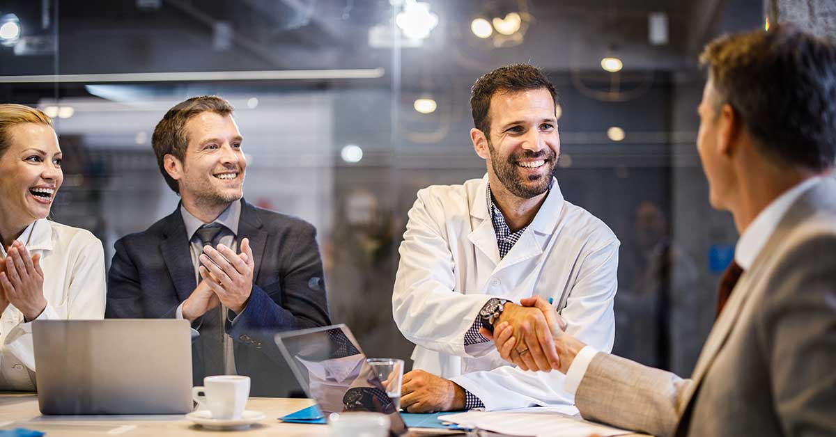 Male physician shaking hands with hospital administrator