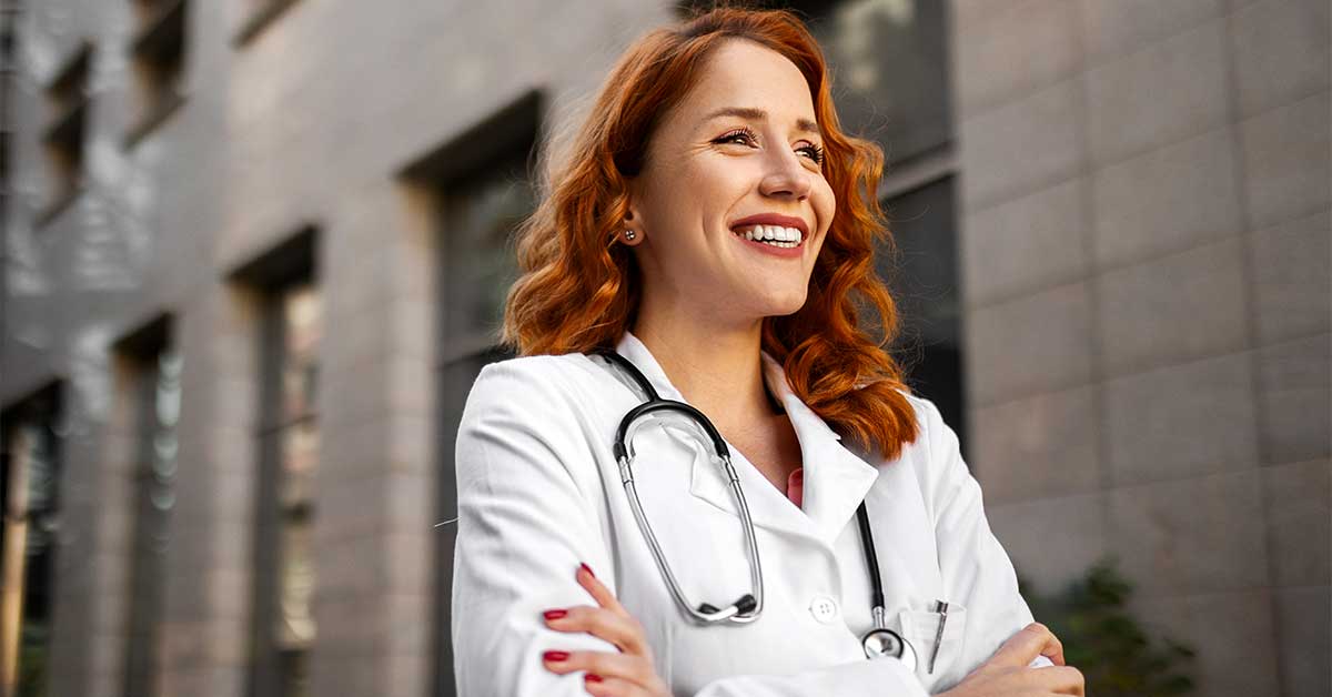 Young, female physician smiling and looking into the distance